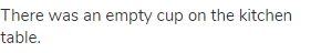 There was an empty cup on the kitchen table.